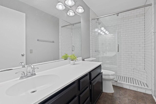 bathroom with a stall shower, vanity, and toilet
