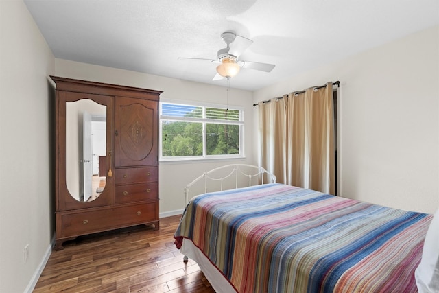 bedroom featuring wood finished floors, baseboards, and a ceiling fan