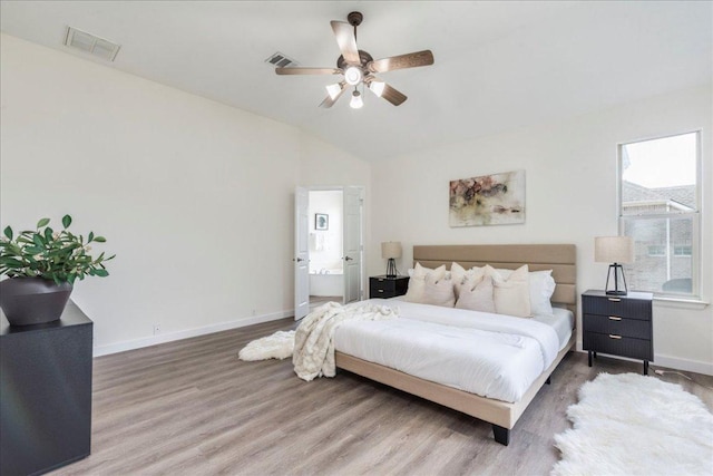 bedroom with baseboards, visible vents, lofted ceiling, a ceiling fan, and wood finished floors