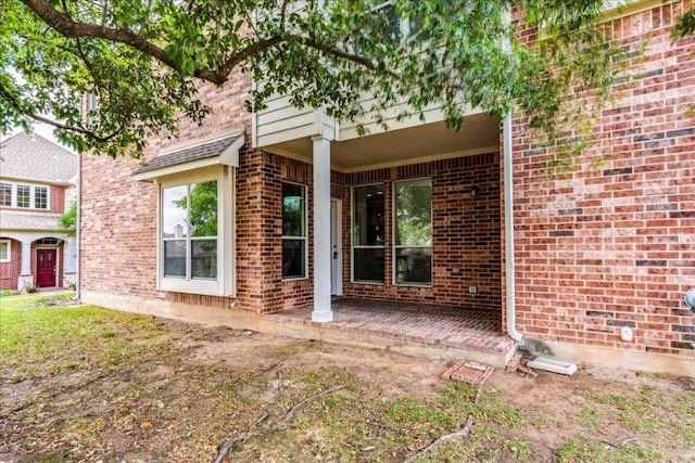 view of exterior entry with brick siding