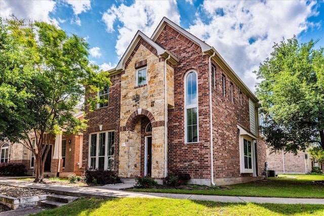 traditional-style house with a front lawn and brick siding