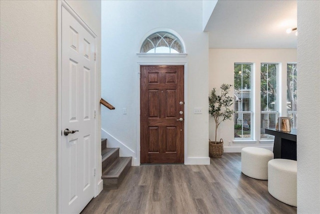 foyer entrance with baseboards, stairs, wood finished floors, and a wealth of natural light