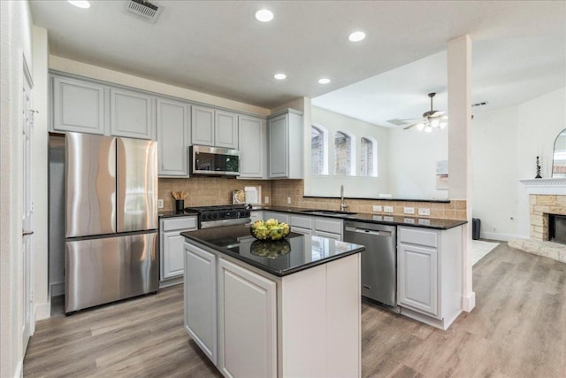 kitchen with appliances with stainless steel finishes, gray cabinetry, light wood-style floors, and visible vents
