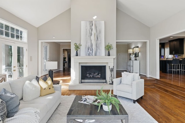 1006 Gaston Ave, Austin, TX 78703 - living area featuring a fireplace with raised hearth, high vaulted ceiling, wood finished floors, and baseboards