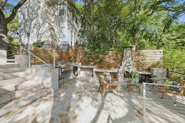 1006 Gaston Ave, Austin, TX 78703 - view of patio featuring grilling area, an outdoor stone fireplace, exterior kitchen, and fence
