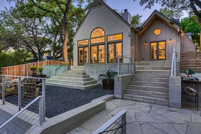 1006 Gaston Ave, Austin, TX 78703 - back of house featuring a chimney, board and batten siding, stairway, fence, and a patio
