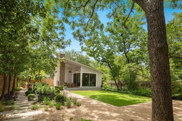 rear view of property featuring stairway, a patio area, a lawn, a chimney, and fence
