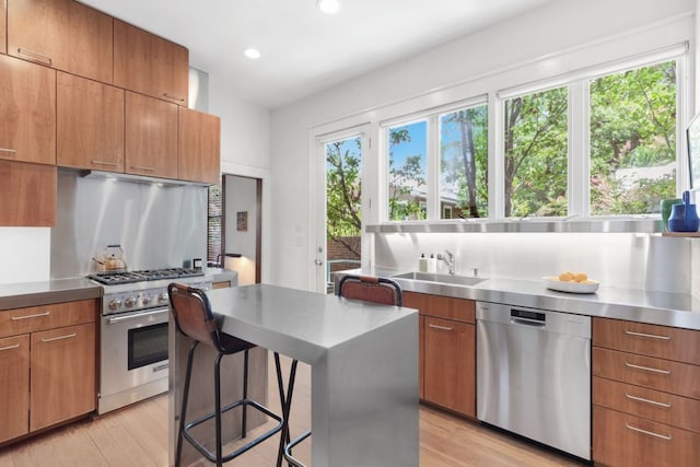 kitchen featuring stainless steel countertops, recessed lighting, light wood finished floors, stainless steel appliances, and modern cabinets