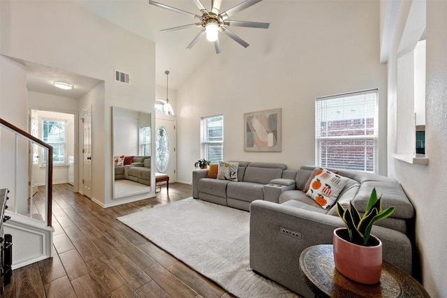 3116 Port Anne Way, Leander, TX 78641 - living room with dark wood finished floors, a ceiling fan, a towering ceiling, stairway, and baseboards