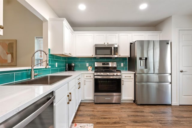 3116 Port Anne Way, Leander, TX 78641 - kitchen with appliances with stainless steel finishes, white cabinetry, a sink, decorative backsplash, and recessed lighting