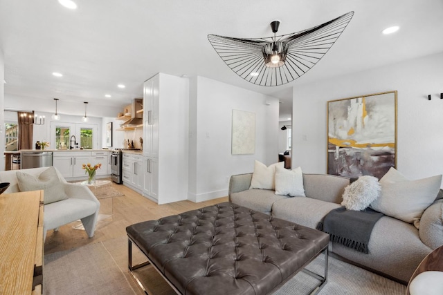 living room featuring light wood-type flooring, recessed lighting, and a chandelier