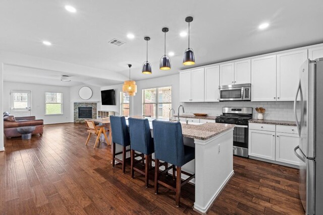 11928 Arran St, Austin, TX 78754 - kitchen with dark wood-type flooring, visible vents, decorative backsplash, open floor plan, and appliances with stainless steel finishes