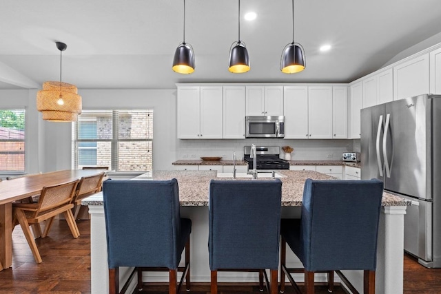 11928 Arran St, Austin, TX 78754 - kitchen with decorative backsplash, stainless steel appliances, dark wood-style flooring, and white cabinetry