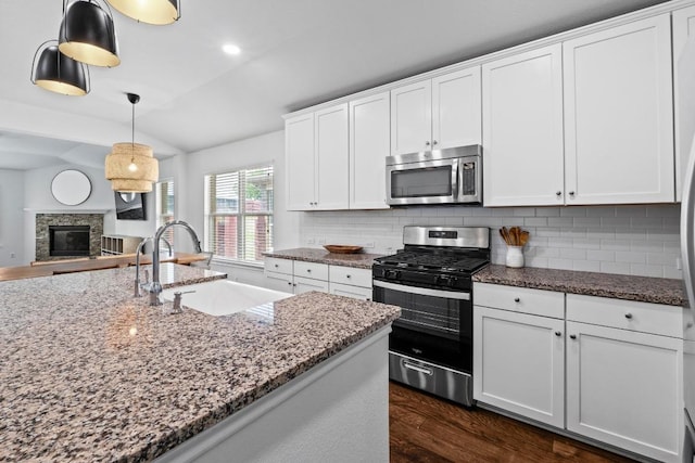 11928 Arran St, Austin, TX 78754 - kitchen with a sink, lofted ceiling, backsplash, dark wood-style floors, and appliances with stainless steel finishes