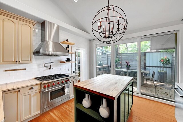 kitchen featuring open shelves, designer stove, wall chimney range hood, vaulted ceiling, and decorative backsplash