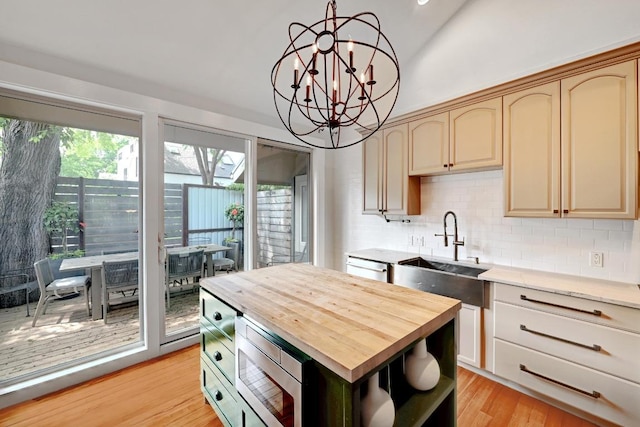 702 W Mary St, Austin, TX 78704 - kitchen with butcher block counters, a sink, stainless steel microwave, decorative backsplash, and vaulted ceiling