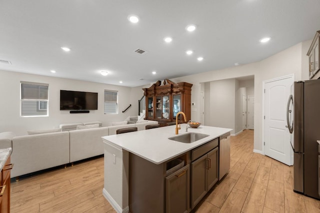 1921 Winston Way, Leander, TX 78641 - kitchen with appliances with stainless steel finishes, light wood-style flooring, light countertops, a center island with sink, and recessed lighting