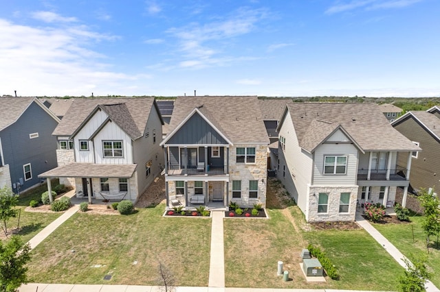 1921 Winston Way, Leander, TX 78641 - townhome / multi-family property with stone siding, board and batten siding, a balcony, covered porch, and a residential view