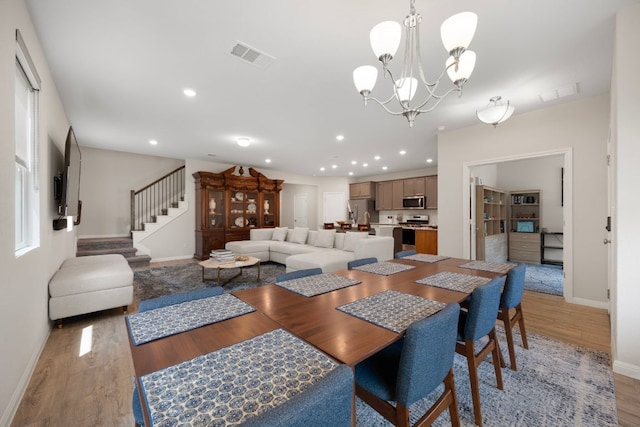 1921 Winston Way, Leander, TX 78641 - dining space featuring light wood-type flooring, a chandelier, stairway, and recessed lighting