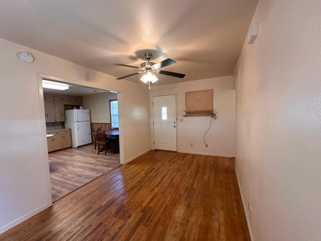foyer with ceiling fan, baseboards, and wood finished floors