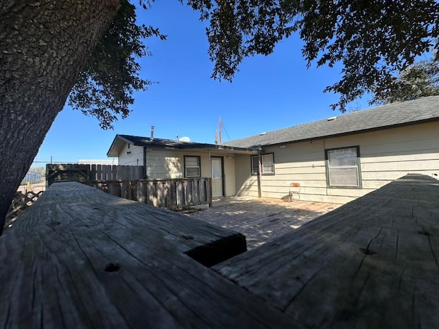 rear view of property with a wooden deck and fence