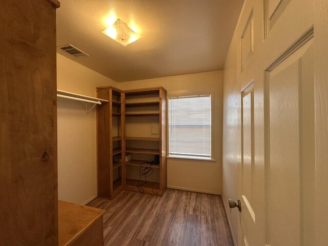 walk in closet with wood finished floors and visible vents