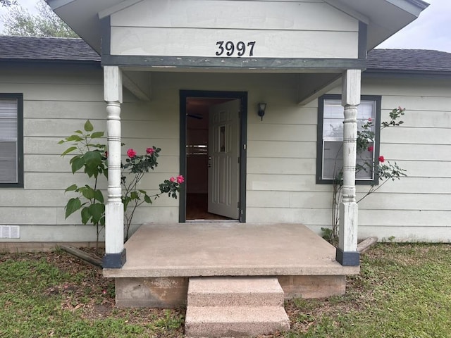 property entrance with a shingled roof