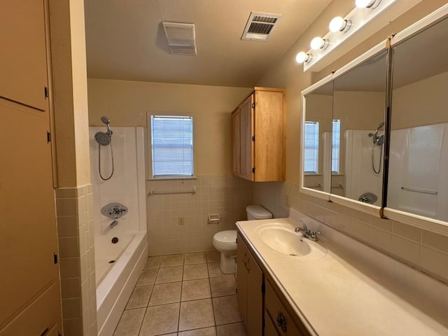 bathroom with tile patterned floors, visible vents, toilet, vanity, and tile walls