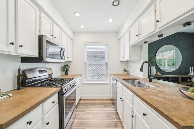 6111 Bridlington Cir, Austin, TX 78745 - kitchen with stainless steel appliances, white cabinetry, light wood finished floors, recessed lighting, and light countertops