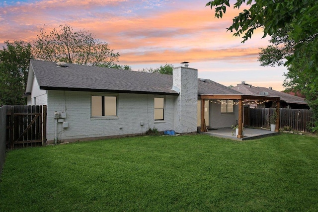 6111 Bridlington Cir, Austin, TX 78745 - back of house at dusk with brick siding, a chimney, a patio, roof with shingles, and a gate