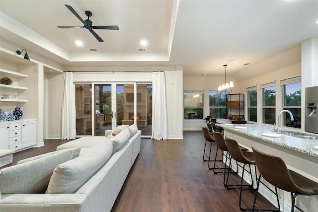 624 Anfield Cir, Austin, TX 78738 - living area featuring a tray ceiling, a ceiling fan, dark wood finished floors, a chandelier, and baseboards