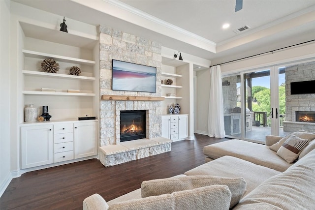 624 Anfield Cir, Austin, TX 78738 - living room featuring a stone fireplace, crown molding, dark wood-style flooring, baseboards, and built in shelves