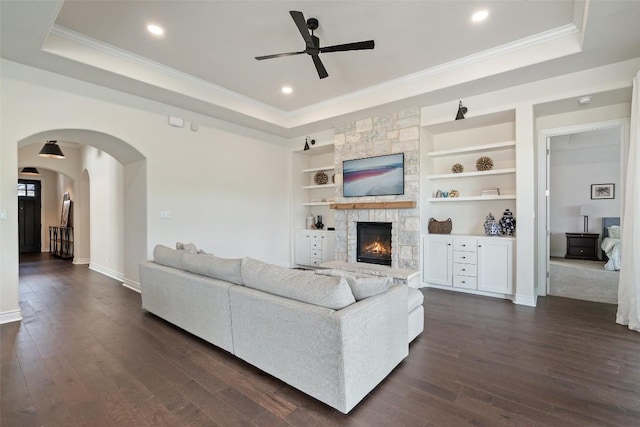 624 Anfield Cir, Austin, TX 78738 - living room with a tray ceiling, a ceiling fan, dark wood-type flooring, arched walkways, and crown molding