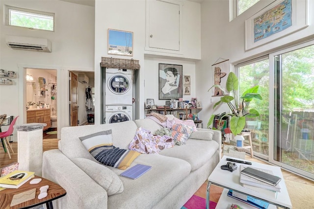 809 E 44th St, Austin, TX 78751 - living area featuring stacked washer / dryer, a towering ceiling, an AC wall unit, and plenty of natural light