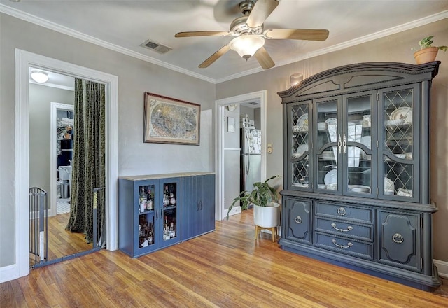 809 E 44th St, Austin, TX 78751 - bar area with ornamental molding, light wood-type flooring, freestanding refrigerator, a ceiling fan, and baseboards