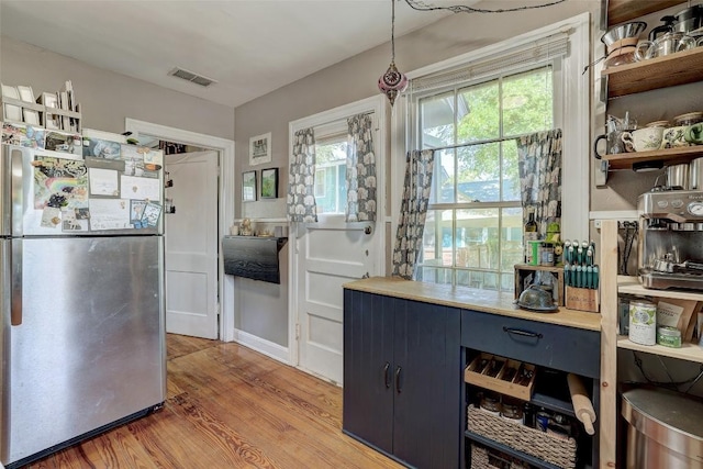 809 E 44th St, Austin, TX 78751 - kitchen featuring freestanding refrigerator, open shelves, light wood-type flooring, and plenty of natural light