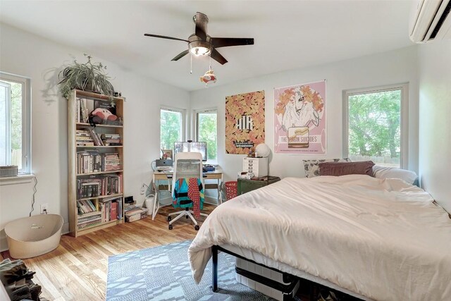 809 E 44th St, Austin, TX 78751 - bedroom with wood finished floors, a wall unit AC, and ceiling fan