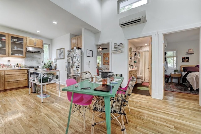 809 E 44th St, Austin, TX 78751 - dining space featuring a wall unit AC, light wood-style flooring, recessed lighting, and a towering ceiling