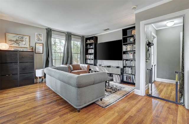 809 E 44th St, Austin, TX 78751 - living room featuring ornamental molding, wood finished floors, built in shelves, and baseboards