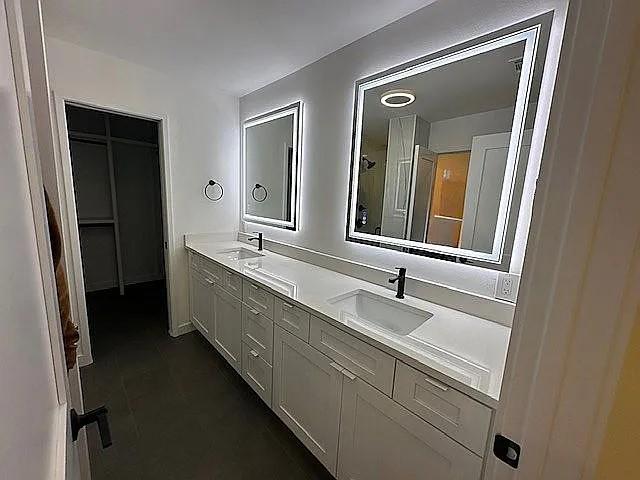 full bath with tile patterned floors, a sink, and double vanity