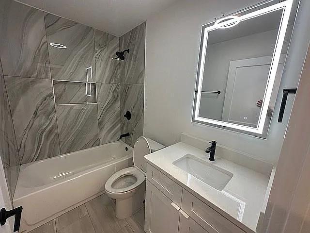 bathroom with tub / shower combination, vanity, and toilet