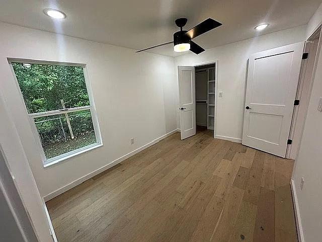 unfurnished bedroom with baseboards, recessed lighting, wood finished floors, a closet, and ceiling fan