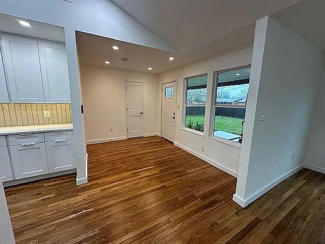 interior space with recessed lighting, dark wood finished floors, lofted ceiling, and baseboards