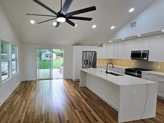kitchen featuring tasteful backsplash, visible vents, stainless steel appliances, and a sink