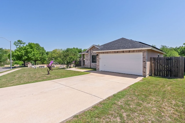 ranch-style home featuring fence, brick siding, a garage, a front yard, and concrete driveway