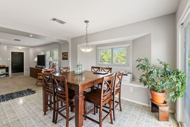 dining room featuring arched walkways and visible vents
