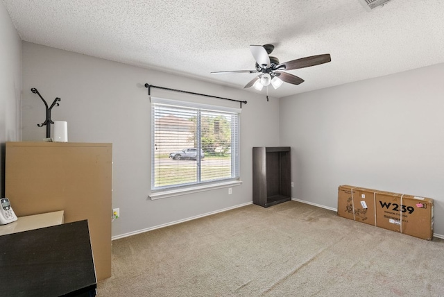 unfurnished bedroom with carpet floors, a textured ceiling, ceiling fan, and baseboards