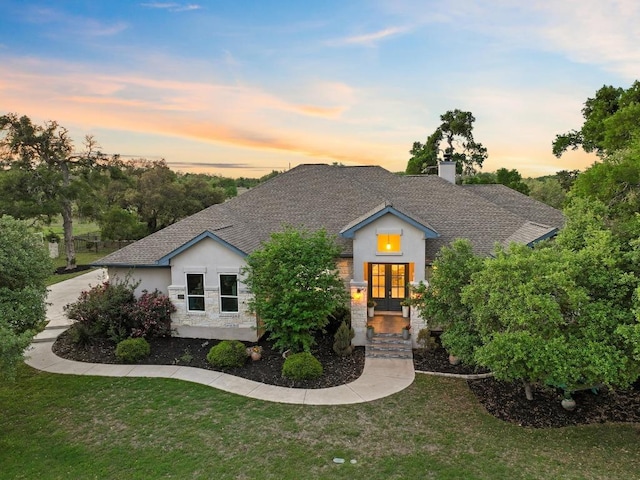 224 Highland Oaks, Leander, TX 78641 - view of front facade with a front lawn, french doors, stucco siding, and a chimney