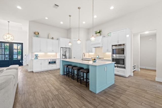 224 Highland Oaks, Leander, TX 78641 - kitchen featuring appliances with stainless steel finishes, a breakfast bar, backsplash, a chandelier, and light countertops