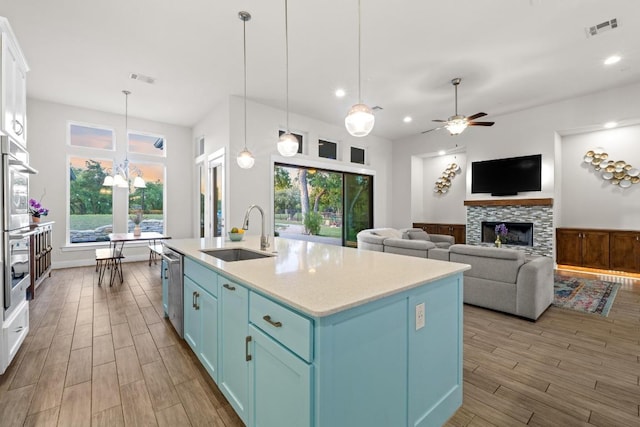 224 Highland Oaks, Leander, TX 78641 - kitchen with light wood-style flooring, blue cabinets, healthy amount of natural light, recessed lighting, and a wainscoted wall